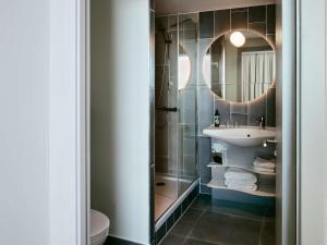 格拉斯哥Aparthotel Adagio Glasgow Central的一间带水槽和镜子的浴室