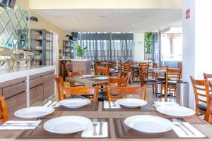 克雷塔罗Comfort Inn Queretaro Tecnologico的一间用餐室,配有白色的板子和木椅