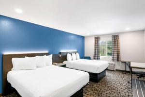 贝瑟尔Econo Lodge Bethel - Danbury的酒店客房设有两张床和蓝色的墙壁。