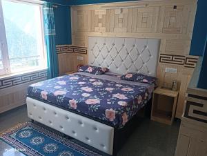 卡尔帕Wanderers Homestay -All mountain facing rooms的一间卧室配有一张蓝色墙壁的床
