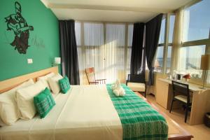普拉亚圣玛丽亚酒店的一间卧室设有一张大床和绿色的墙壁