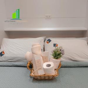 达斯马里尼亚斯SMDC Green 2 Staycation in Dasma的床上的带毛巾和鲜花的篮子