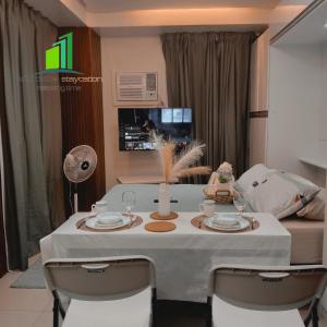 达斯马里尼亚斯SMDC Green 2 Staycation in Dasma的餐桌、白色桌布和椅子