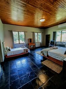 雾观Linvale Country Lodge的一间卧室设有两张床和木制天花板