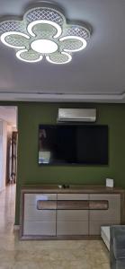 萨伊迪耶très belle maison avec jardin et piscine的客厅设有一台平面电视,位于绿色的墙壁上