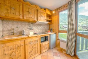 里雾诗Le Prarion 63B - Happy Rentals的一个带木制橱柜和大窗户的厨房