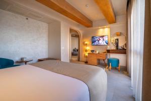 艾因苏赫纳Al Masa Hotel El Sokhna的一间卧室配有一张床、一张书桌和一台电视