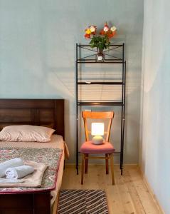 库塔伊西Moedani-Very Center Apartments in Kutaisi的一间卧室配有椅子和一个带花瓶的架子