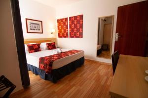 普拉亚圣玛丽亚酒店的一间卧室配有一张带红色枕头的床