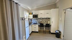 逊邱伦189 Luxury Suite的厨房配有白色橱柜和白色冰箱。