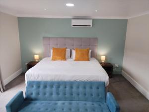 阿尔弗雷德港迈邦德斯坦登酒店的一间卧室配有一张大床和一张蓝色的沙发