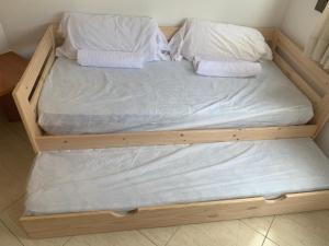 罗列特海岸Oliva Mar的一张带白色床单和枕头的木床