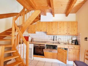 尼海姆Natur-Ferienpark的一间带木制橱柜和螺旋楼梯的厨房