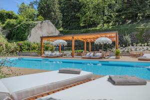 贝拉吉奥Diamond Apartments的游泳池旁的游泳池配有椅子和遮阳伞
