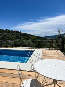 ArnascoAgriturismo Le Merline的一个带桌椅的庭院和一个游泳池