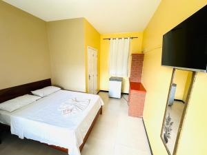 阿拉卡茹蒲莎达阿卡兰托酒店的一间卧室配有一张床和一台平面电视