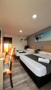 麦德林Hotel Gran Conquistador 33的酒店客房,设有两张床和一张沙发