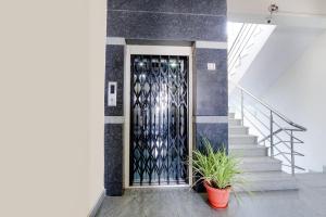 海得拉巴FabHotel Namaha Suites - Nr Hyderabad Airport的一座有盆栽植物的建筑的门