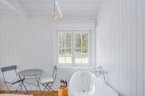 恩古雷Coastal Cabin Engure的带浴缸和桌椅的浴室