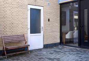 埃因霍温The Suite Eindhoven by T&S的坐在门前的木凳
