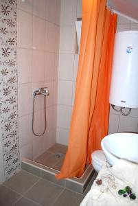 索科矿泉村Apartmani Ema的浴室内配有橙色淋浴帘和卫生间