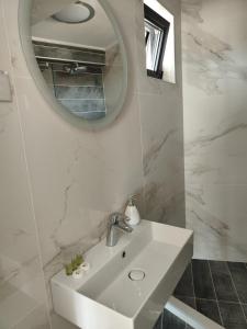 布尔加斯Marina Sarafovo的白色的浴室设有水槽和镜子