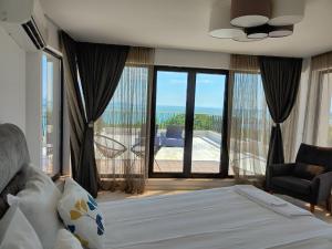 布尔加斯Marina Sarafovo的一间卧室配有一张床,享有海景