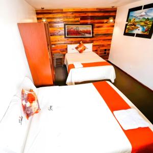 阿亚库乔Ayacucho Plaza的酒店客房设有两张床和木墙