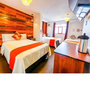 阿亚库乔Ayacucho Plaza的酒店客房设有两张床和木墙