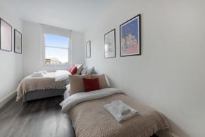 伦敦Studio 6- Archway Station的白色的客房设有两张床和窗户。