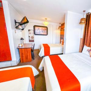 阿亚库乔Ayacucho Plaza的酒店客房配有两张床和一张书桌