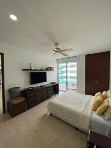 卡塔赫纳APARTAMENTO MORROS922 LA BOQUILLA con acceso directo a la Playa的一间卧室配有一张床和一台平面电视