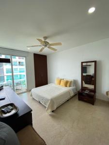 卡塔赫纳APARTAMENTO MORROS922 LA BOQUILLA con acceso directo a la Playa的一间卧室配有一张床和吊扇