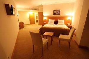 Velimeşe新罗酒店的酒店客房带一张床、一张桌子和椅子