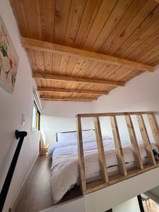派帕Corinto Tiny House的木天花板的客房内的一张床位