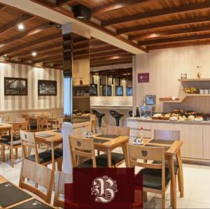 格拉玛多Bellagio Mini Resort - no coração de Gramado的餐厅设有木桌、椅子和柜台