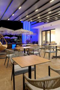 卡萨米尔Ori Mare Hotel的一间带桌椅和遮阳伞的餐厅
