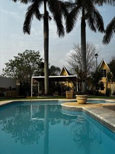 加尔潘VILLAS EL ENCANTO的一座别墅前方的棕榈树游泳池
