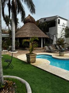 加尔潘VILLAS EL ENCANTO的一个带稻草伞的游泳池的度假酒店