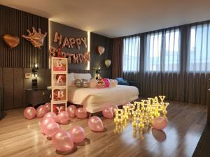 花莲市花蓮品悅文旅Hualien Pink Corner Hotel的一间卧室,配有一张带气球和一束蜡烛的床