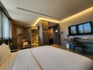 花莲市花蓮品悅文旅Hualien Pink Corner Hotel的一间卧室配有一张大床和一张书桌
