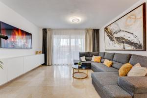 圣地亚哥港Luxury Holiday House Tenerife的客厅配有灰色的沙发和电视