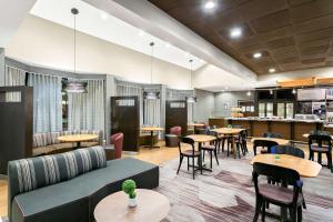 绿带城Sonesta Select Greenbelt College Park的一间带桌椅的餐厅和一间酒吧