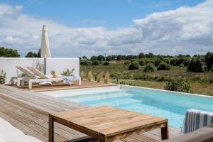 孔波尔塔Villa Possanco, Comporta beach villa的一个带木甲板和桌椅的游泳池