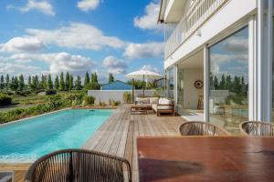孔波尔塔Villa Possanco, Comporta beach villa的一个带桌椅的庭院和一个游泳池