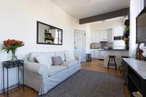 纽约Sunny Stylish West Village Condo的一间带白色沙发的客厅和一间厨房