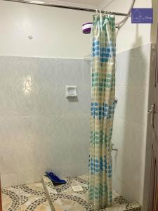 内罗毕Utulivu House的浴室铺有瓷砖地板,配有淋浴帘