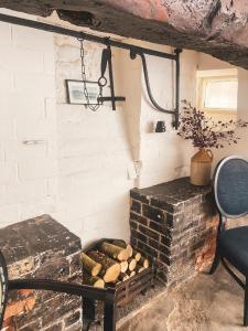 约维尔The New Inn的一间设有砖砌壁炉并靠近椅子的房间