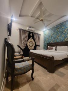 伊斯兰堡BED & Breakfast ISLAMABAD的一间卧室配有一张带吊扇和椅子的床