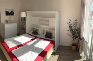 费曼城堡Am Rundsteg 4的一间卧室配有一张带红白毯子的床